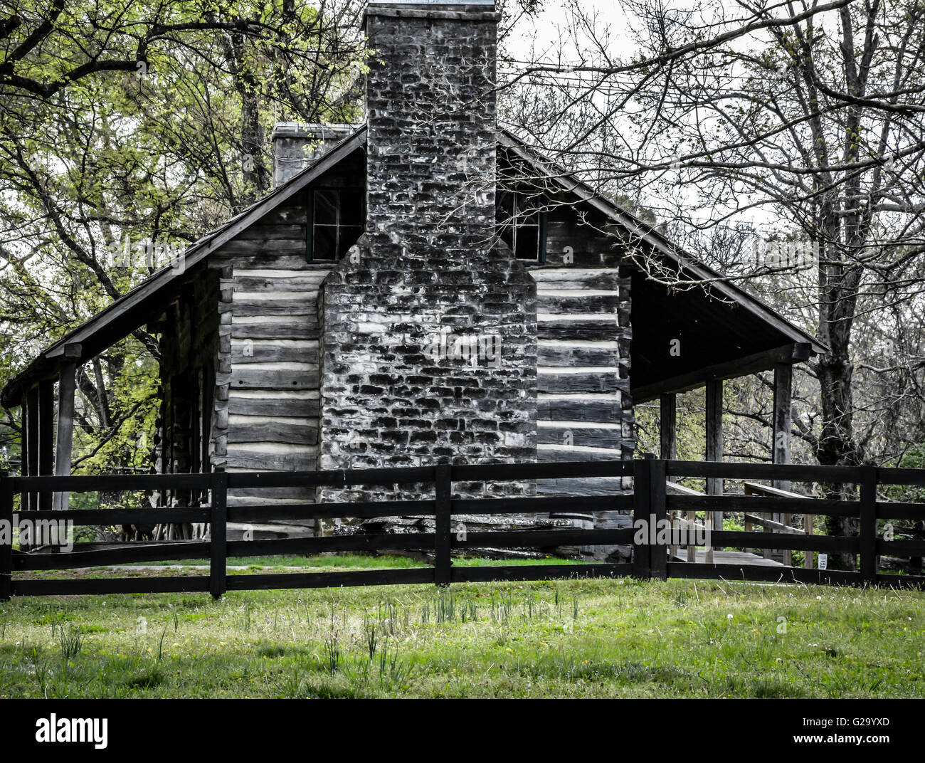 Un affascinante stile rustico log cabin con portico anteriore & camino nero e recinzione in legno in un edificio del XIX secolo stile è bella e semplicistico Foto Stock