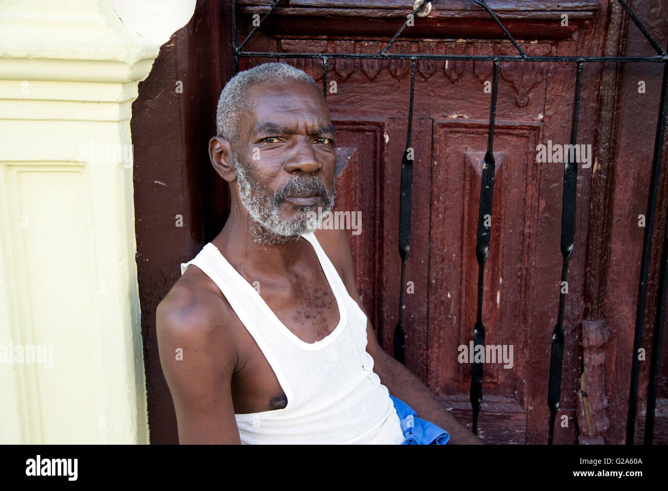 Ritratto di un cubano uomo seduto alla porta della sua casa a Cienfuegos Cuba Foto Stock