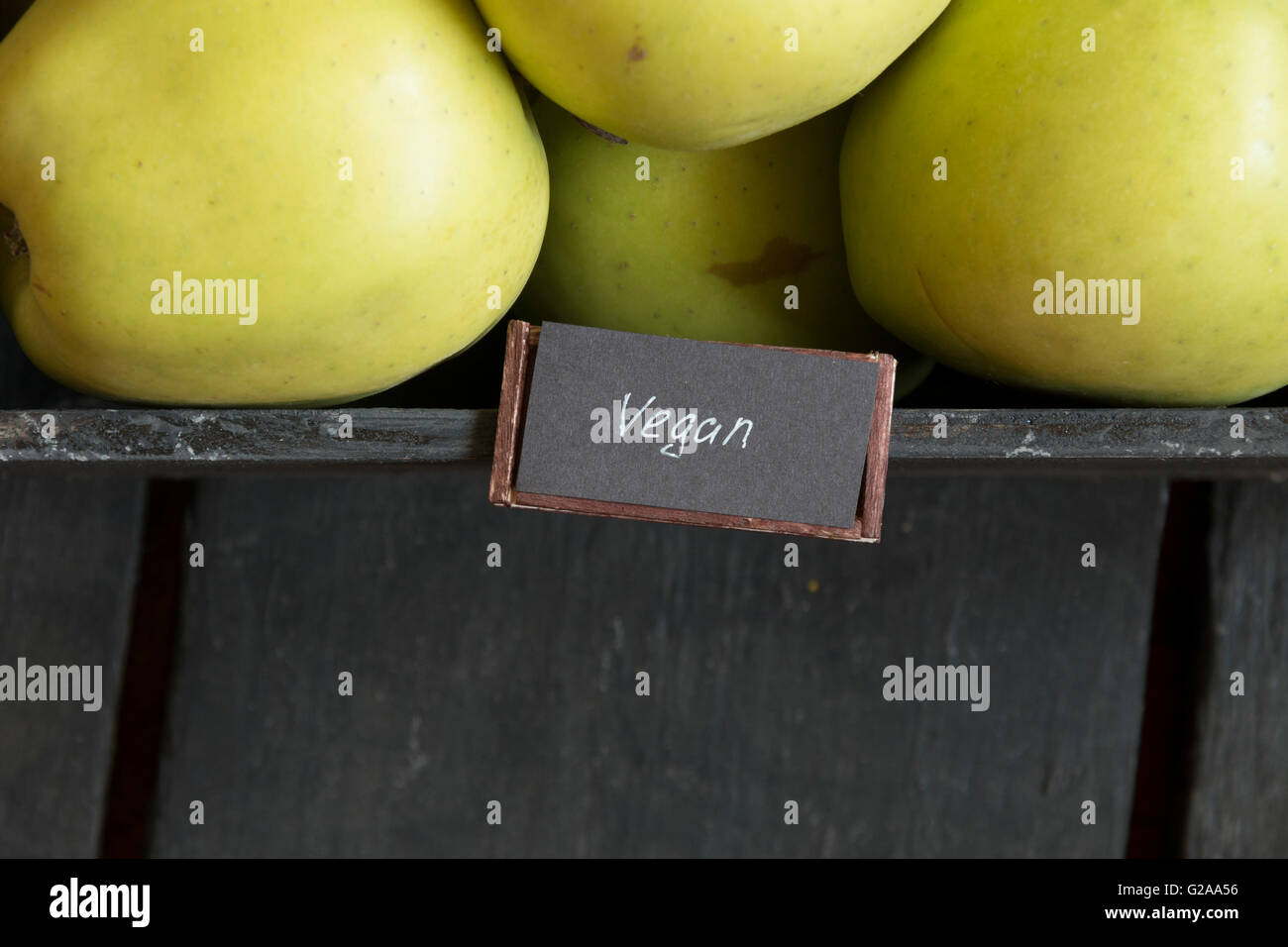 Cibo vegan idea, mela verde su un tavolo e testo Foto Stock