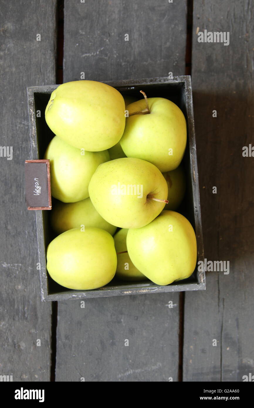 Cibo vegan idea, mela verde su un tavolo e testo Foto Stock