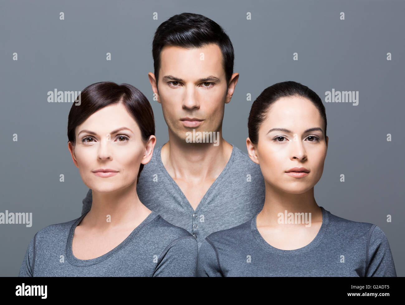Uomo e due donne che indossano cime grigio Foto Stock