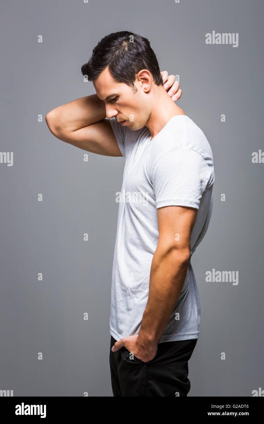 Uomo in t-shirt bianco su sfondo grigio Foto Stock