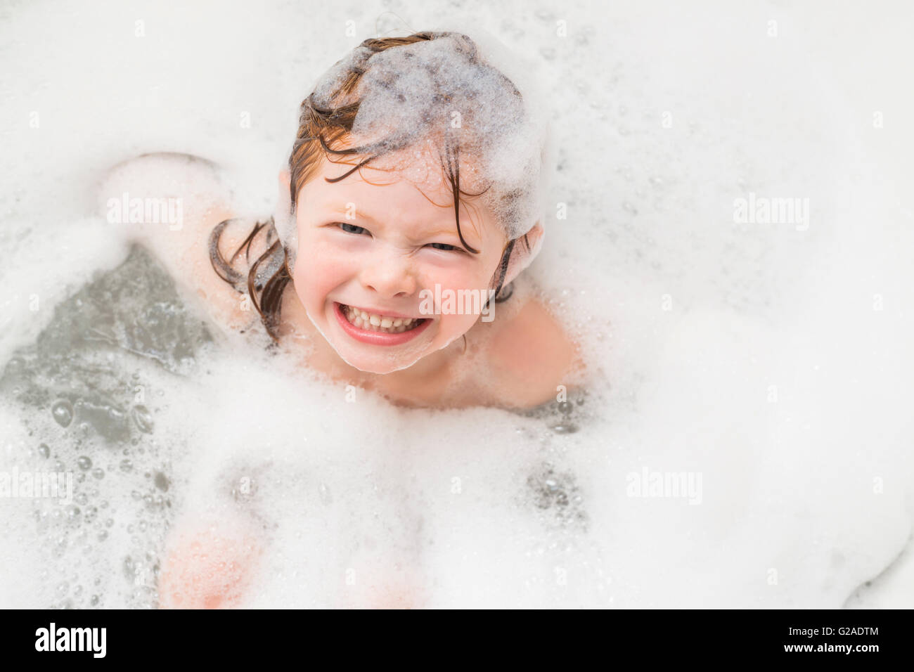 Ragazza sorridente (4-5) avente bubble bath Foto Stock