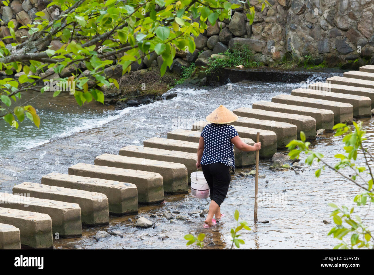 Imprenditore da un ponte in pietra che attraversa il fiume, provincia del Fujian, Cina Foto Stock