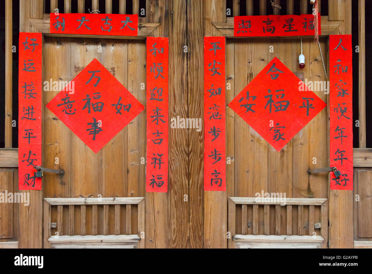 Porta di una casa di villaggio con decor di rosso posters e baciata, Nanjing County, provincia del Fujian, Cina Foto Stock