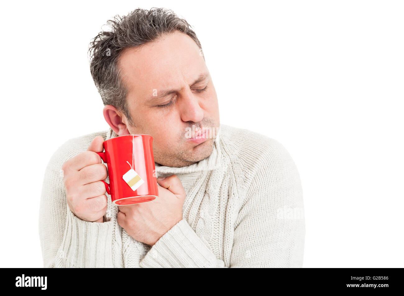 Uomo freddo tenendo la tazza di tè e brividi di freddo a causa del virus influenzale Foto Stock