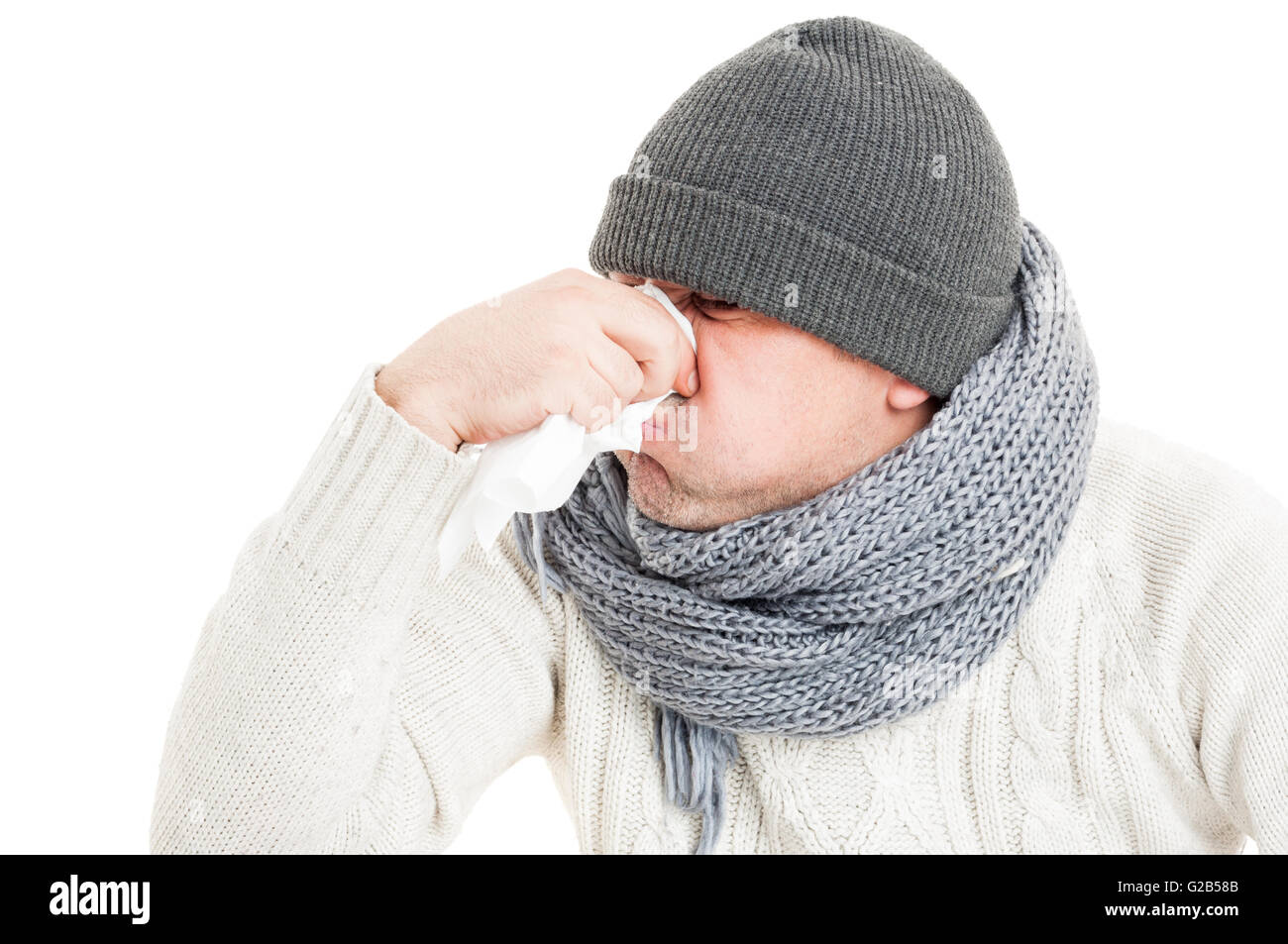 Uomo freddo soffia il naso sul tovagliolo di carta o hanky isolati su sfondo bianco Foto Stock
