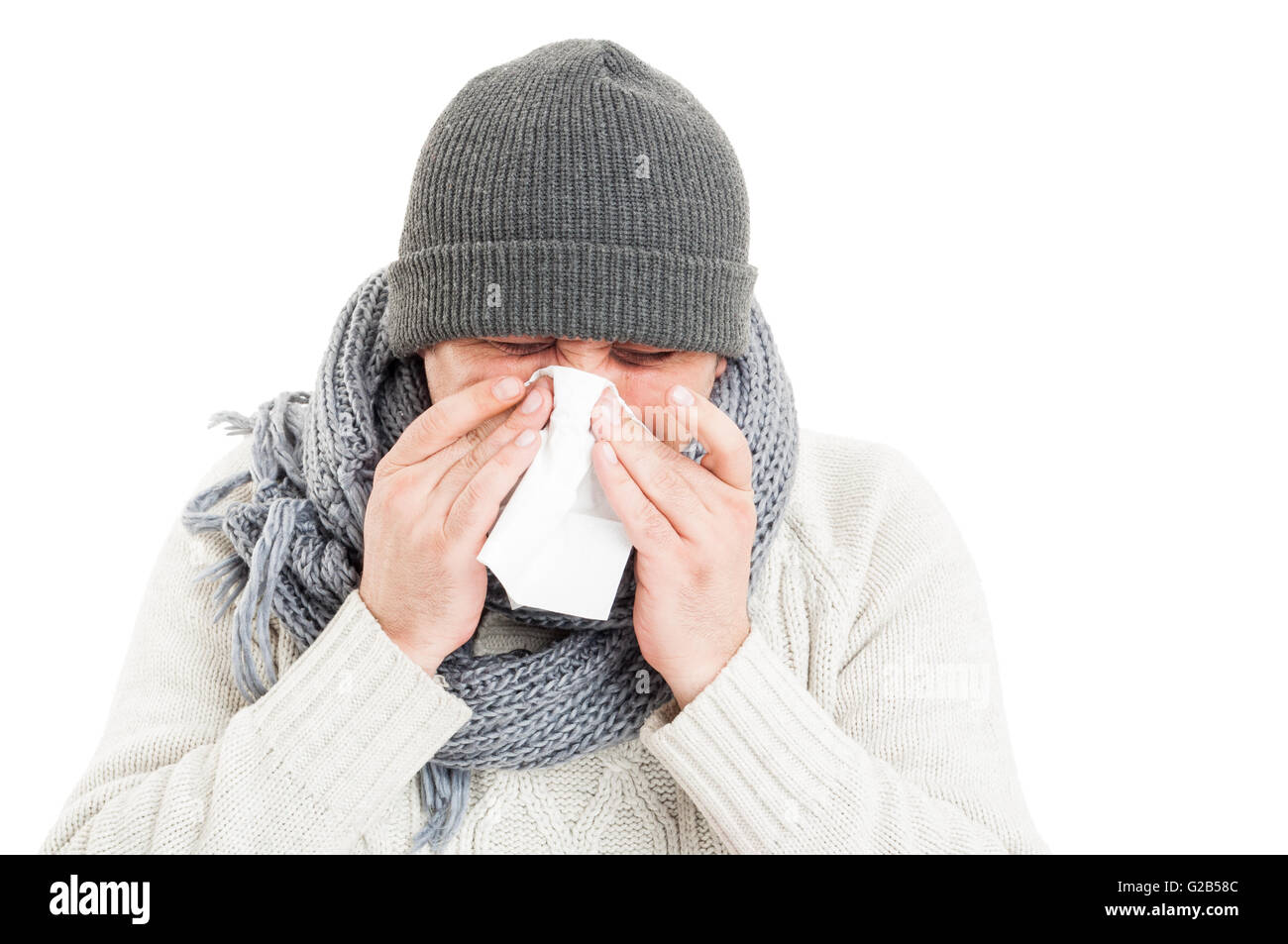 Uomo freddo indossando hat, sciarpa e un maglione, soffia il naso Foto Stock
