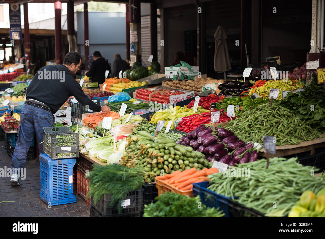 Dimotiki Agora mercato dei prodotti freschi Atene Grecia // ATENE, Grecia — prodotti freschi in vendita presso la Dimotiki Agora, nota anche come Varvakios Agora, nel centro di Atene. Il mercato è il più grande mercato al dettaglio di cibo fresco della città, caratterizzato da numerose bancarelle che offrono una variegata gamma di frutta e verdura locali. L'Agorà Dimotiki è una destinazione popolare per la gente del posto e i turisti, che mette in mostra l'abbondanza e la varietà di prodotti greci. Foto Stock