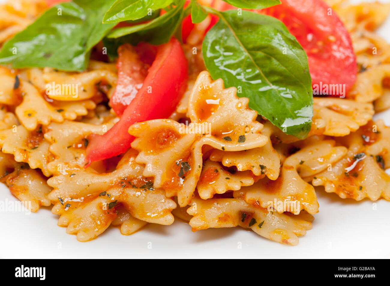 La pasta italiana Le farfalle butterfly bow tie-in pomodoro con salsa al basilico bianco su tavola in legno rustico Foto Stock