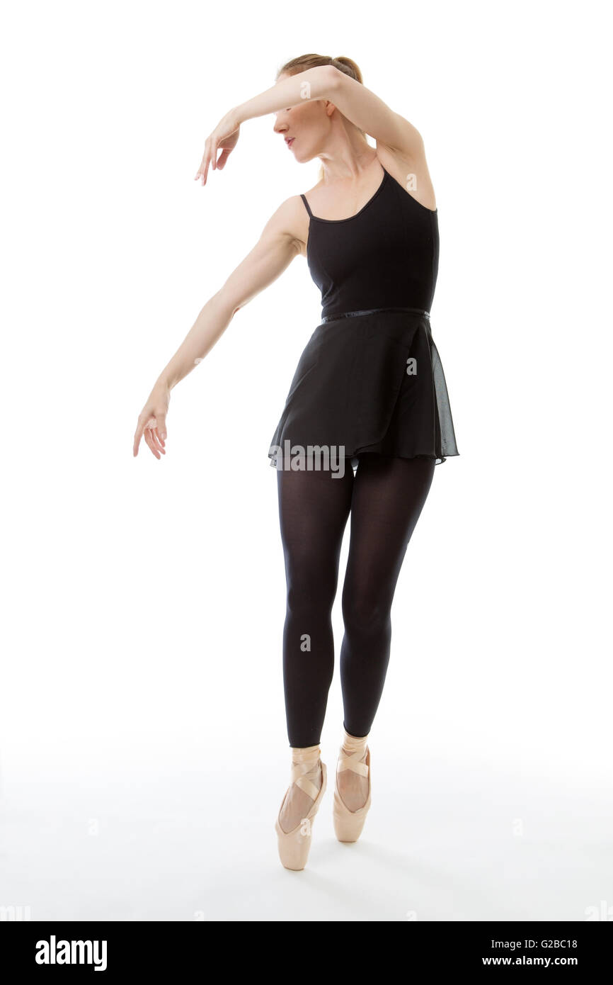 Lunghezza completa studio shot di una bellissima ballerina, en pointe,  vestito in un tutto nero danza tuta con le braccia sollevate al Foto stock  - Alamy