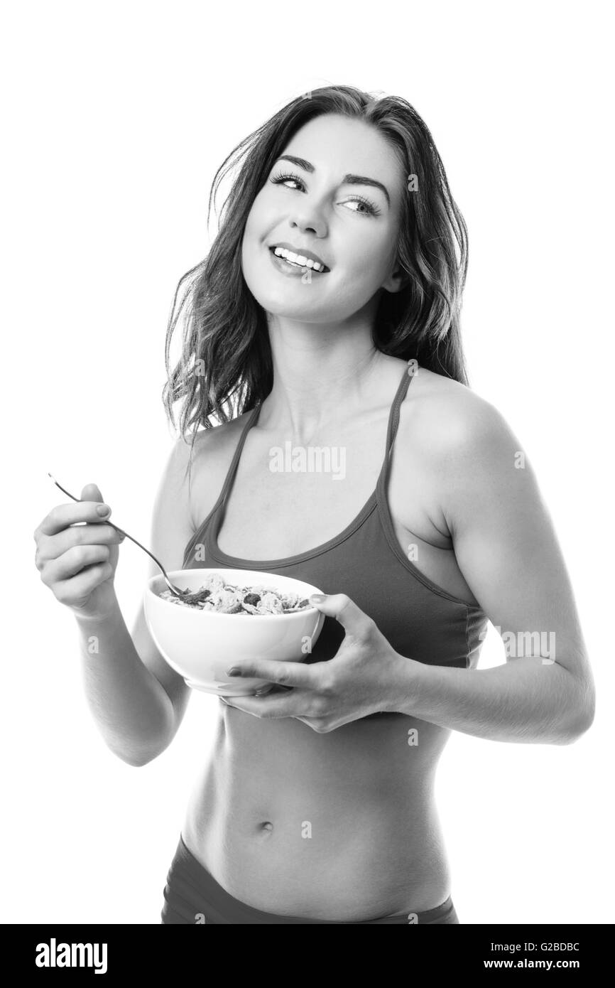 Close up studio shot di un bel giovane modello fitness mangiare una tazza di cereali per la prima colazione Foto Stock