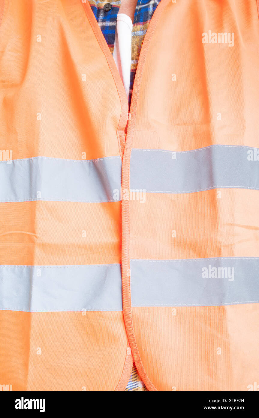 Sicurezza concetto di costruzione con ingegnere maschio indossa la protezione arancione gilet con strisce riflettenti in close-up Foto Stock