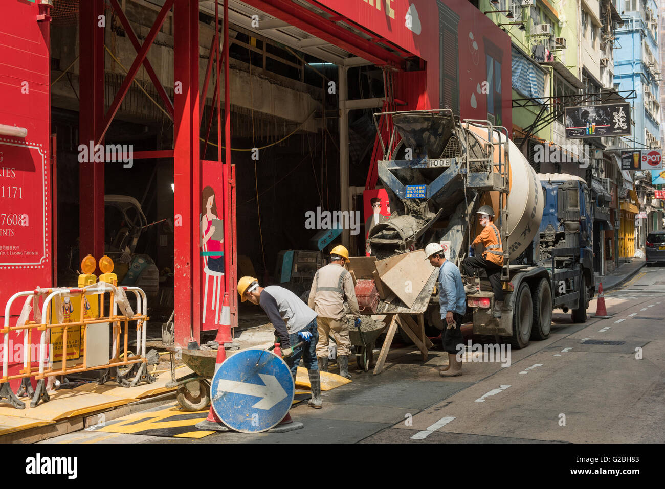 Lavoratori edili wheelbarrowing calcestruzzo, Hong Kong Foto Stock