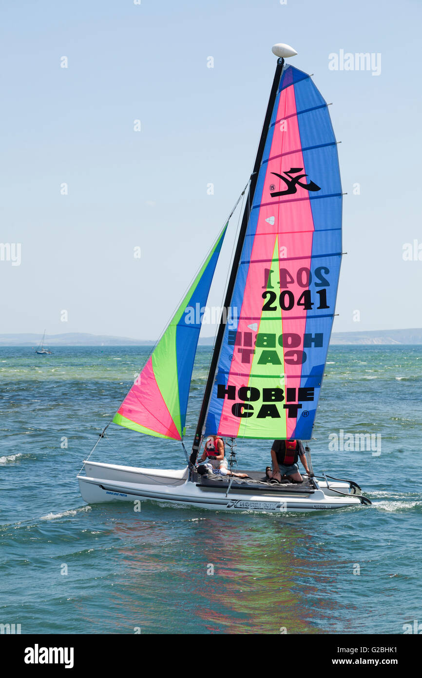 Due persone in barca a vela su un Hobie Cat catamarano, Dorset, England, Regno Unito Foto Stock