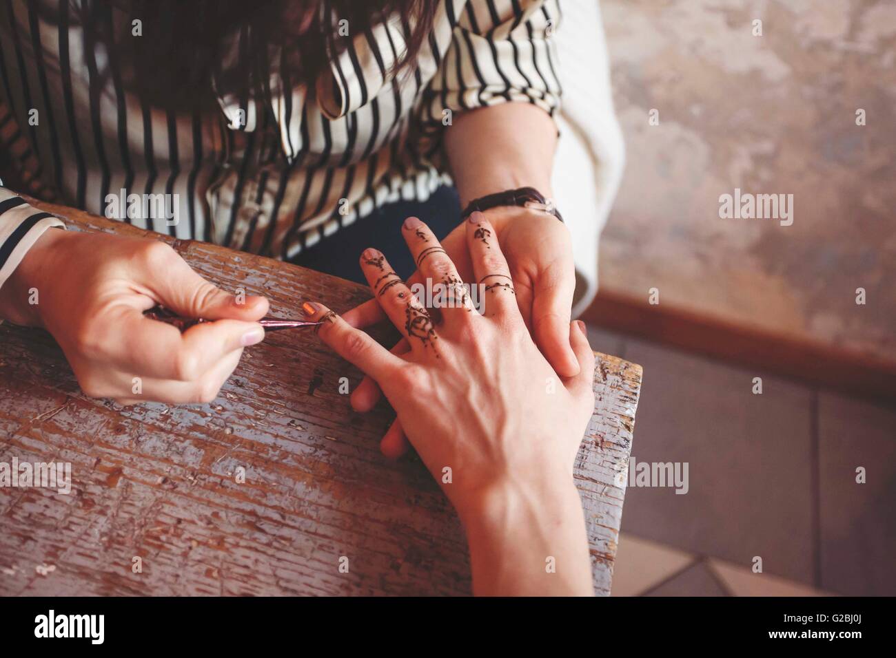 Artista creazione tradizionale pittura hennè Mehndi sulle mani femminili Foto Stock