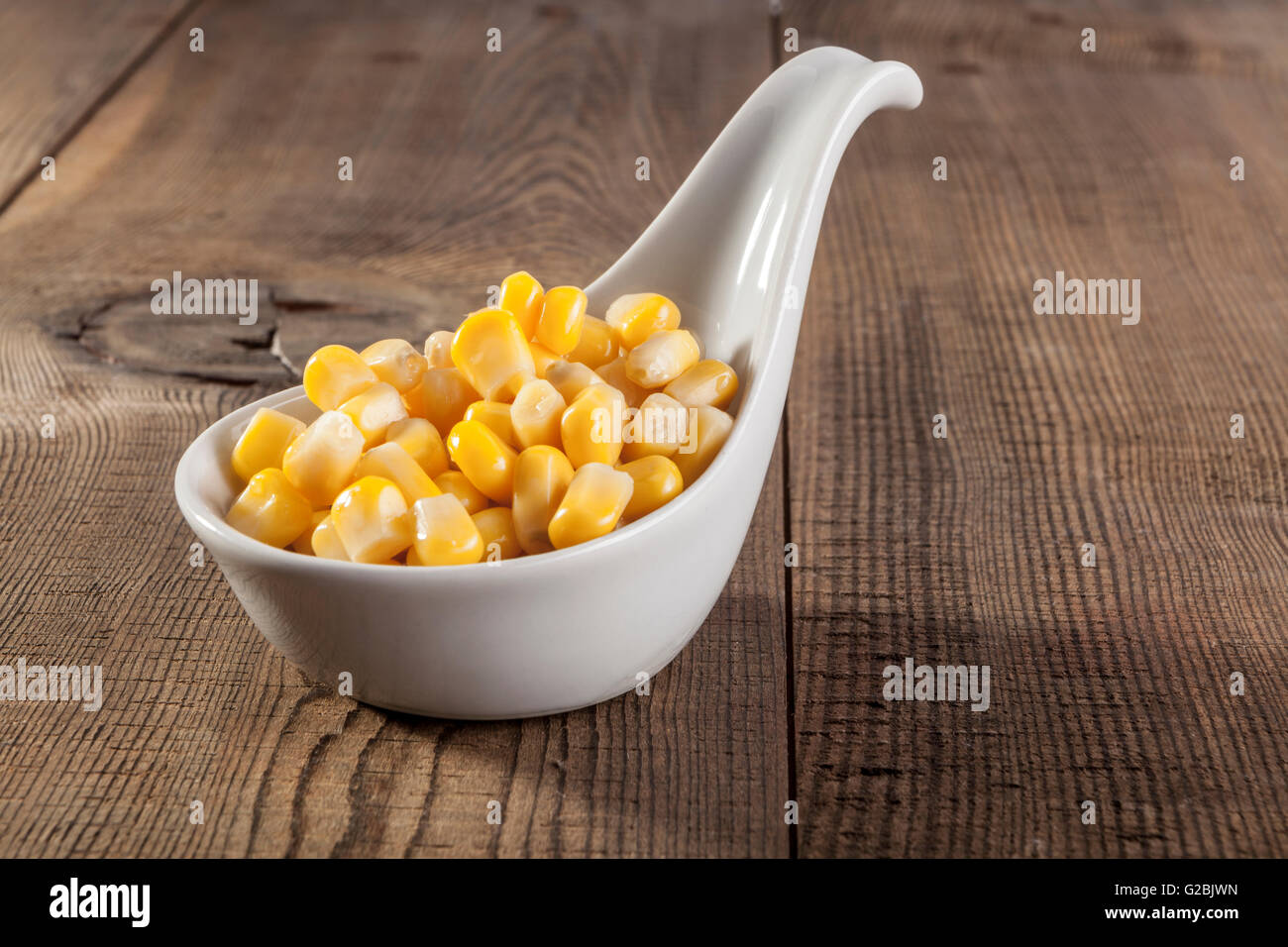 Giallo dolci chicchi di mais sulla tavola di legno Foto Stock