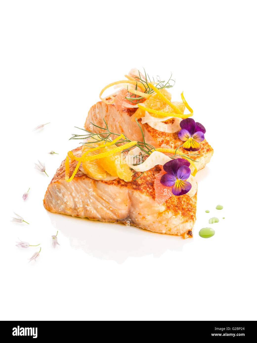 Due pezzi di filetti di salmone con pesche e fiori commestibili su uno sfondo bianco. Foto Stock