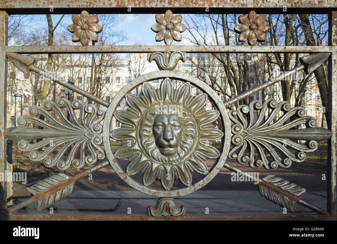 Vista frontale della testa di leone in cornice rotonda. Decorazione del vecchio recinto metallico nel centro storico di San Pietroburgo, Russia Foto Stock