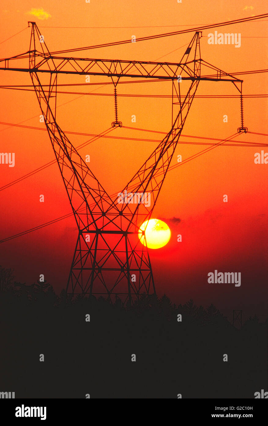 Il tramonto visto attraverso la trasmissione elettrica di linee di potenza e la torre, Upstate New York, Stati Uniti d'America Foto Stock