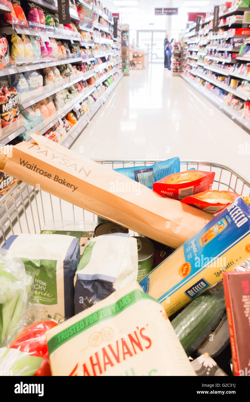 Waitrose carrello della spesa pieno di negozi di generi alimentari nel corridoio commerciale Foto Stock