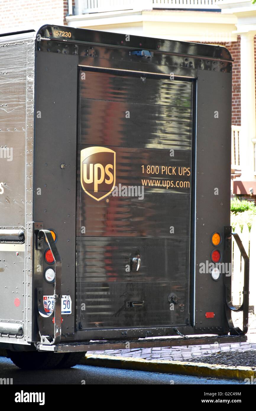 Un UPS carrello parcheggiato sulla strada mentre il conducente effettua una consegna Foto Stock