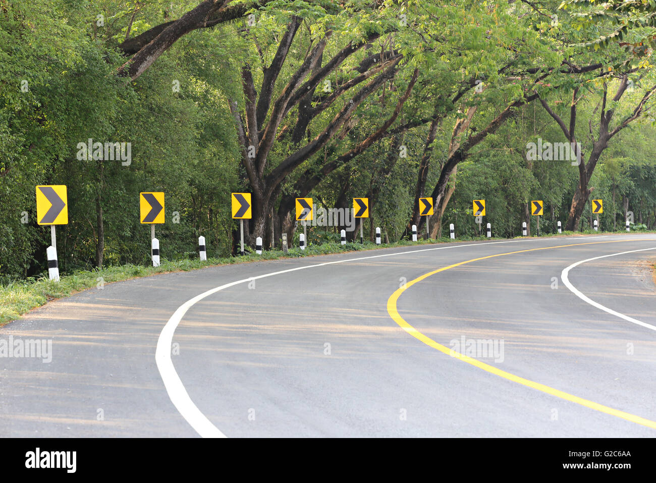 La strada curva con via segni di luce reflex,a notte si possono vedere i segni più chiaramente. Foto Stock