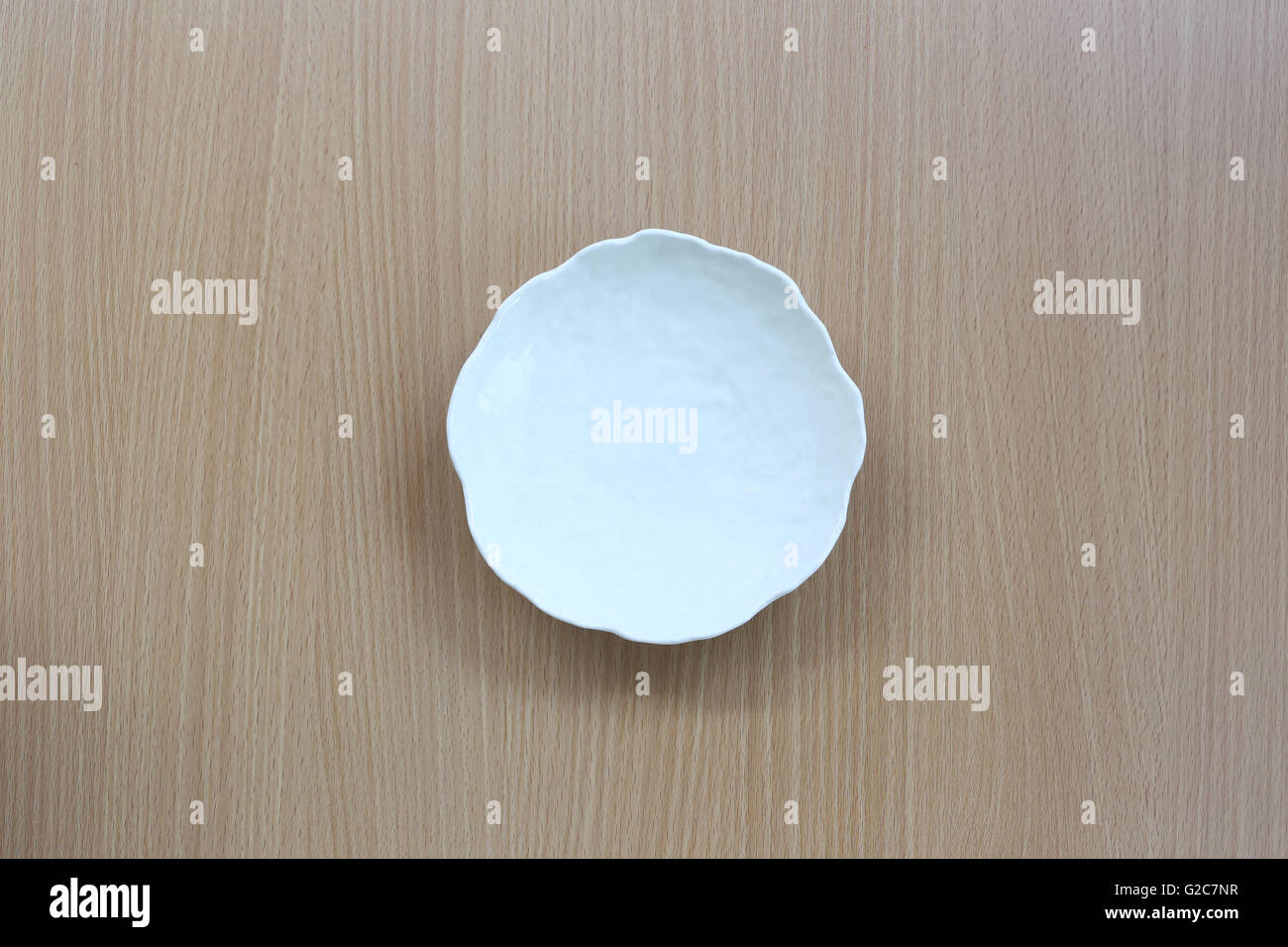 Piatto bianco in vista dall'alto su uno sfondo di legno per il design concept food. Foto Stock