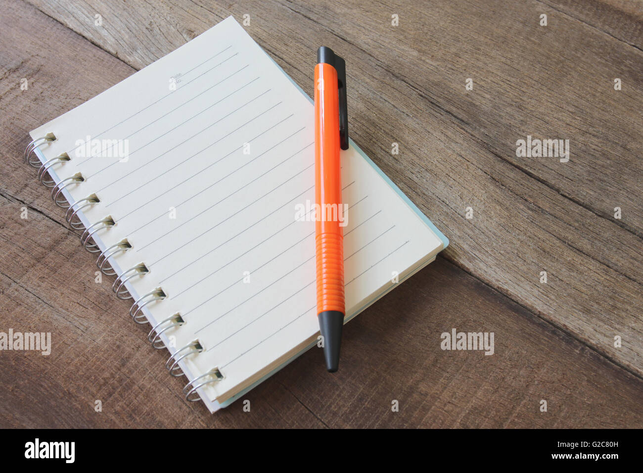 Notebook vuota e il colore della penna sul pavimento in legno per la progettazione dello sfondo. Foto Stock