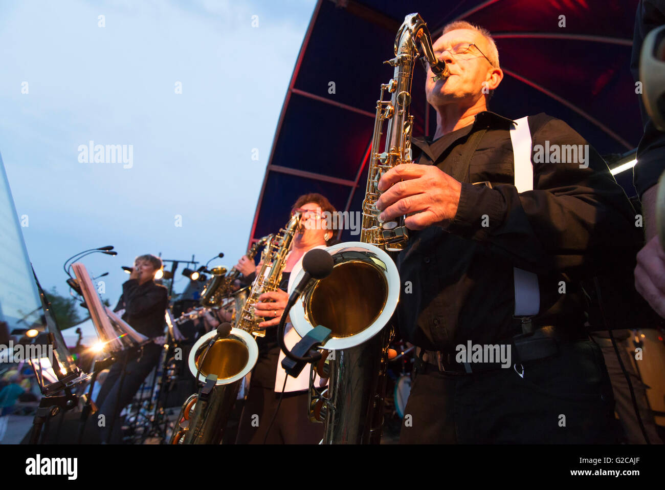 Band sul palco con musicisti che suonano strumenti in ottone in una serata estiva Foto Stock