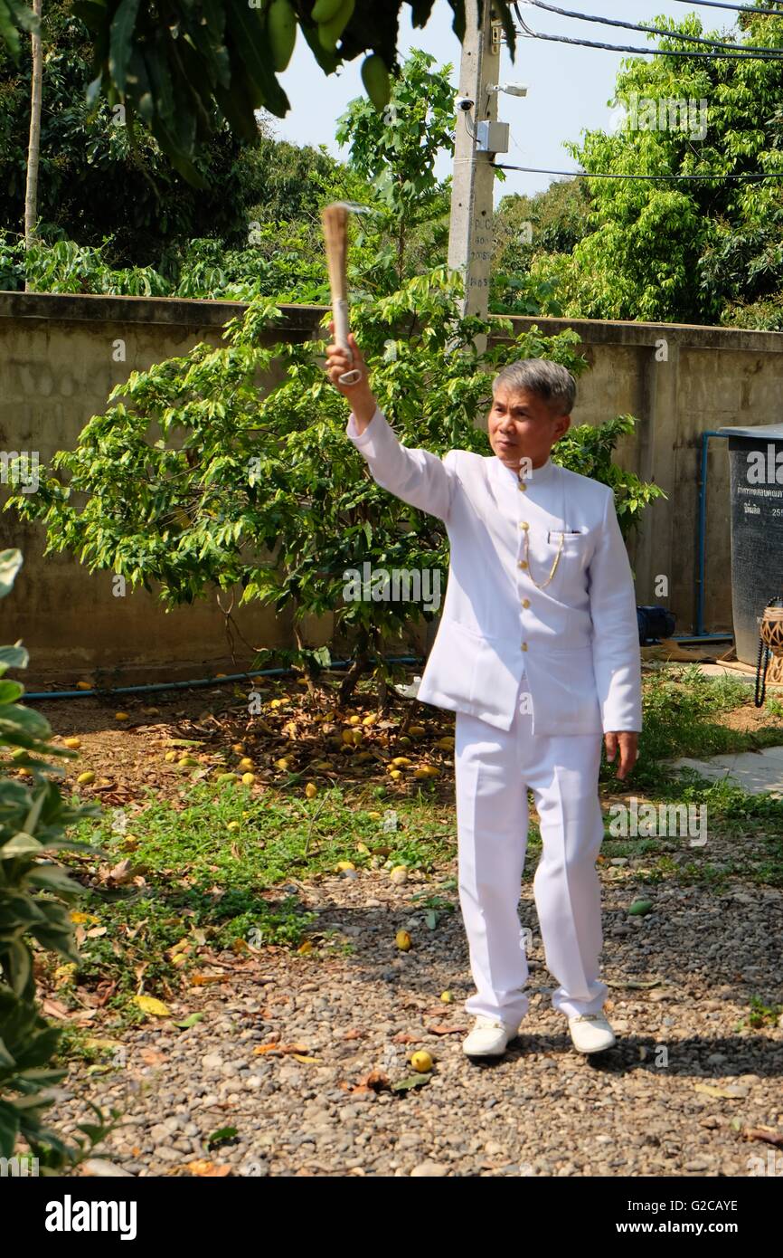 Chiang Mai, Thailandia - 15 maggio 2016. Sacerdote bramino spruzza acqua lustrale sulla proprietà a casa lo spirito che istituisce la cerimonia. Foto Stock