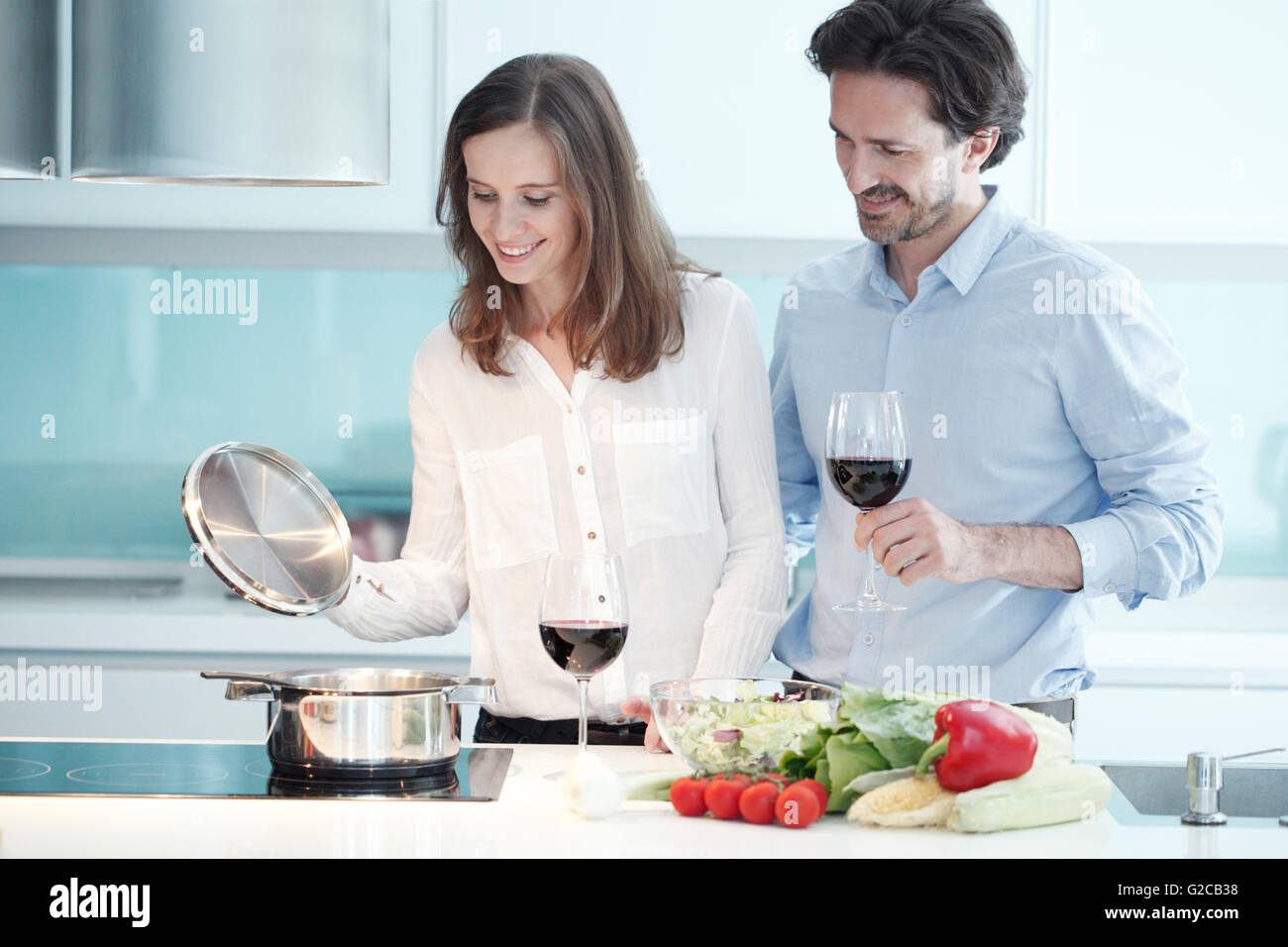 Ritratto di un giovane con un bicchiere di vino rosso durante la cena di cucina Foto Stock