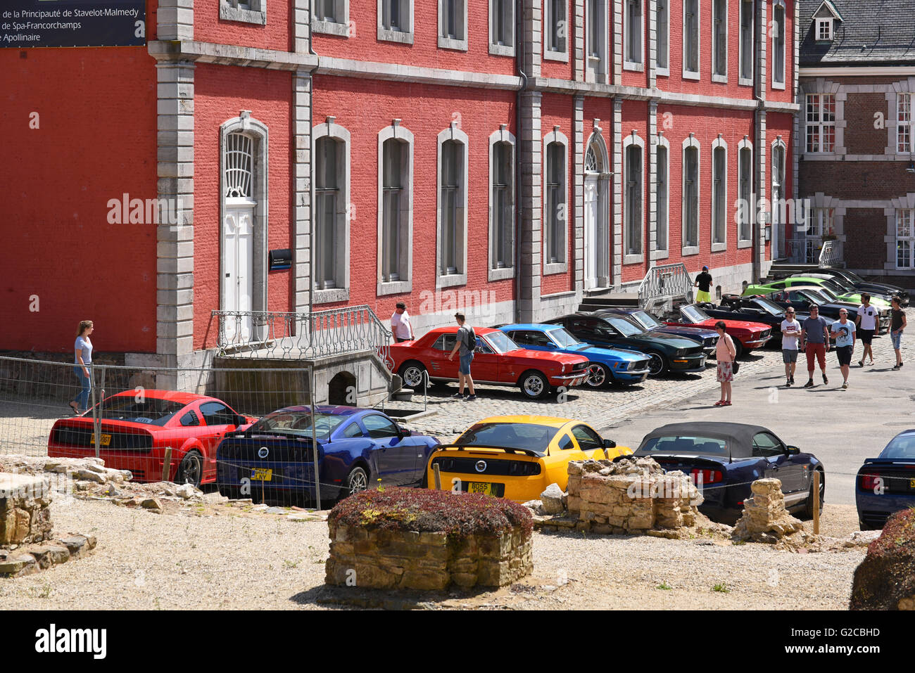 Ford Mustang owners club prendere una pausa e parcheggiare i loro veicoli presso l'Abbazia di cortile durante il loro tour del Belgio. Foto Stock