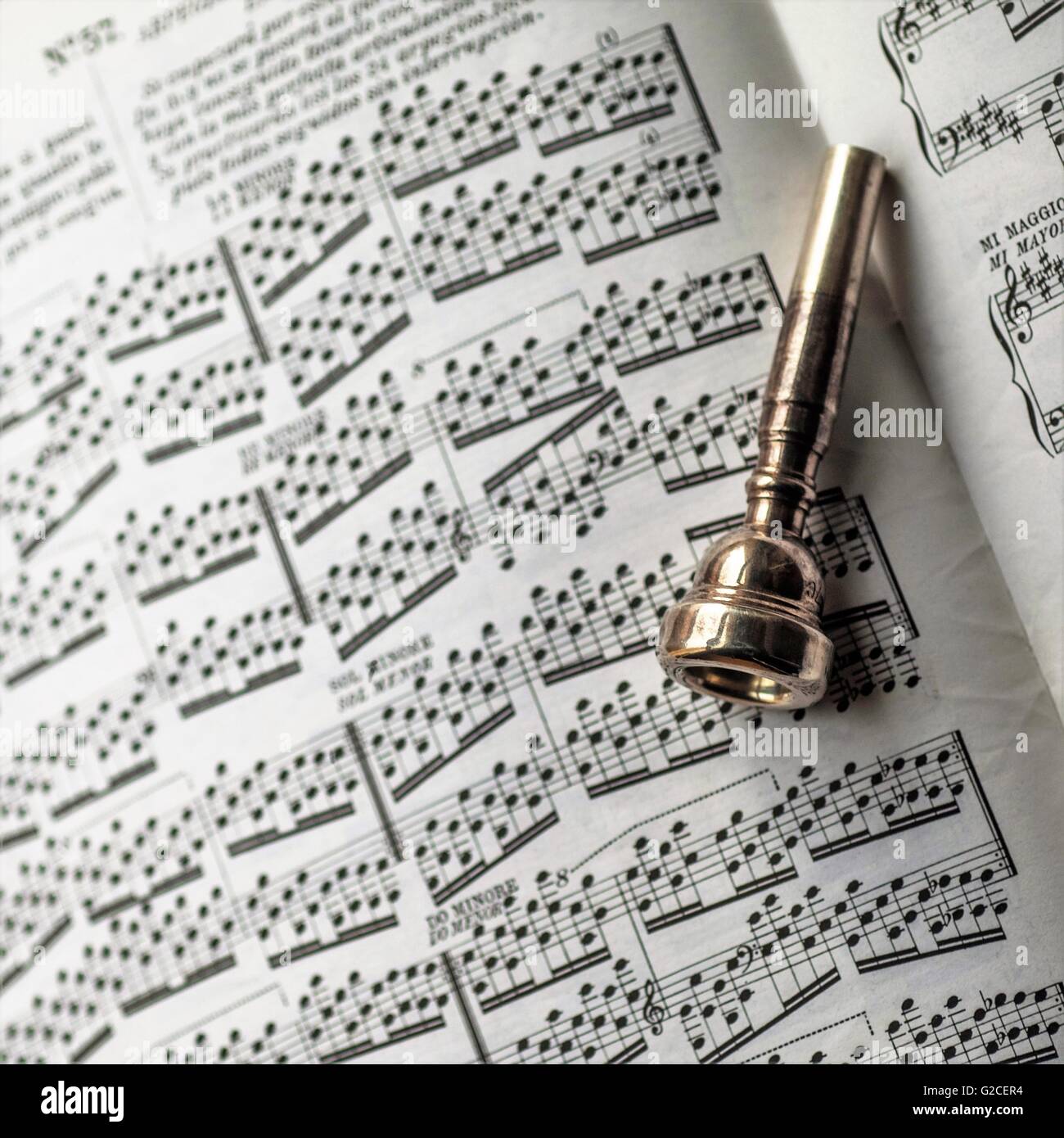 Tromba boccaglio poste su un libro di fogli di musica Foto Stock