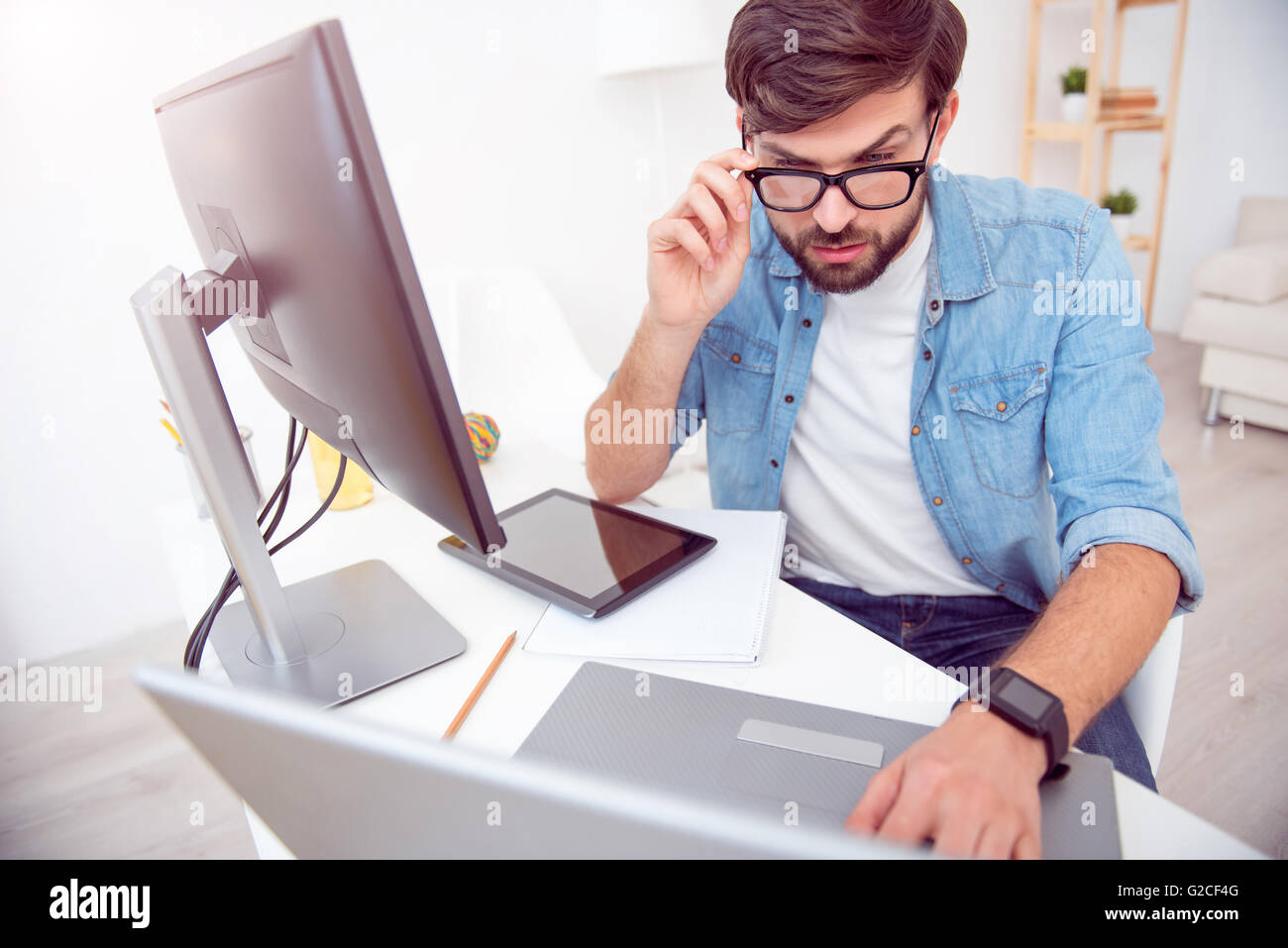 Uomo serio lavoro sul suo computer portatile Foto Stock