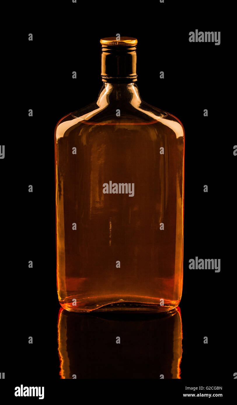 Isolato con tracciati di ritaglio singola bottiglia di whiskey con la riflessione. Colori caldi immagine Foto Stock