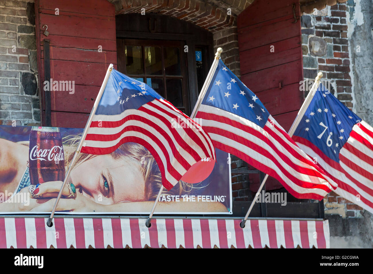 Savannah, Georgia - un messaggio pubblicitario per la Coca Cola, circondato da bandiere, sul fiume Street nel centro storico della città. Foto Stock