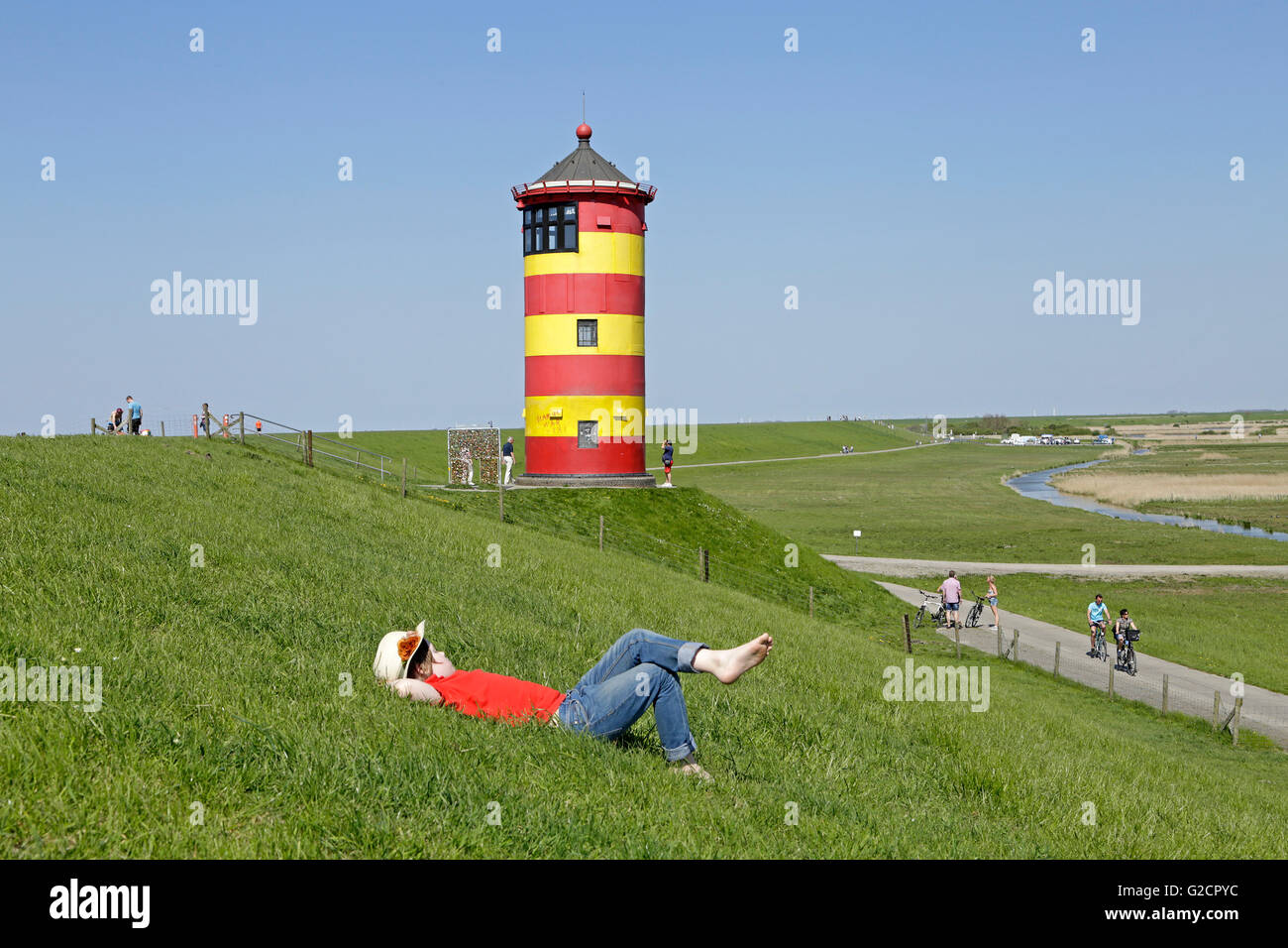 Ragazzo giovane nella parte anteriore del faro Pilsum, Pilsum, East Friesland, Bassa Sassonia, Germania Foto Stock