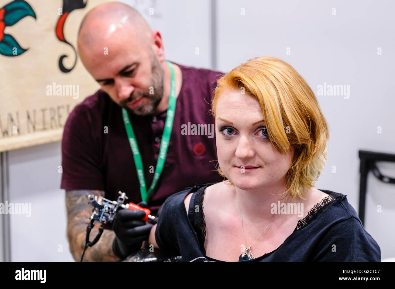 BELFAST, IRLANDA DEL NORD. 28 MAGGIO 2016 - 6th Conferenza del Tattoo dell'Irlanda del Nord. Una cliente femminile ha un tatuaggio sulla sua parte superiore del braccio Foto Stock