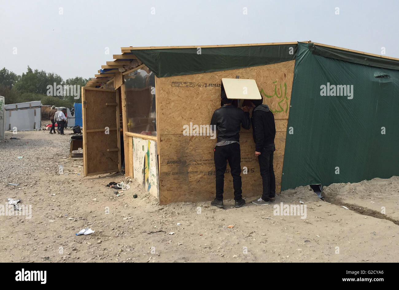Calais, Francia. 27 Maggio, 2016. Due uomini sono alla ricerca all'interno di una capanna di fortuna nel campo migrante soprannominato "Jungle' nella periferia di Calais, Francia, 27 maggio 2016. Quaranta persone sono rimaste ferite in una rissa al campo profughi, le autorità locali ha detto. Diversi rifugi sono stati bruciati. Foto: Anna Psaroudakis/dpa/Alamy Live News Foto Stock