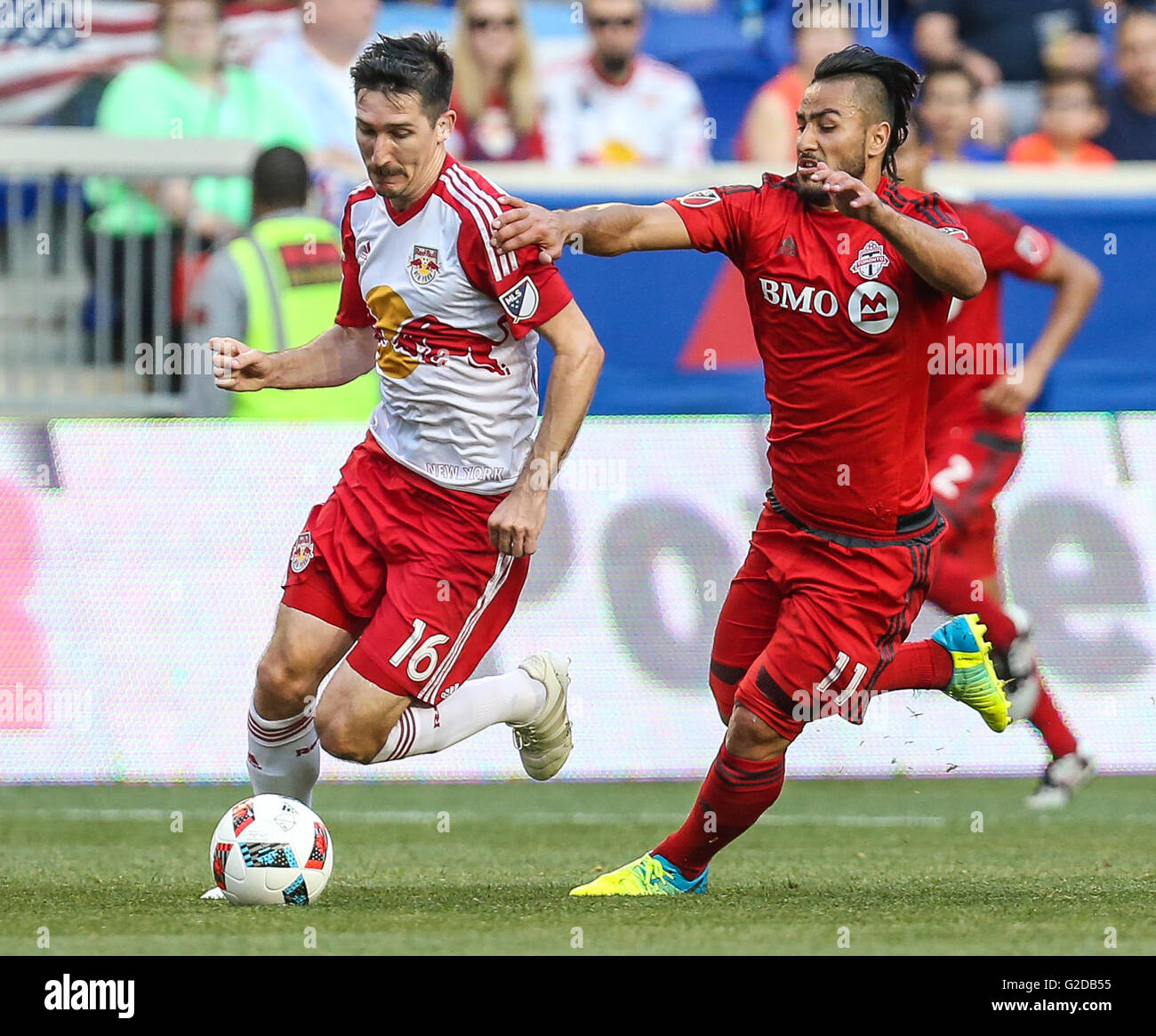 Harrison, NJ, Stati Uniti d'America. 28 Maggio, 2016. Toronto FC in avanti Babouli Mo (11) cerca di rallentare New York Red Bulls centrocampista Sacha Kljestan (16) durante una sequenza di lunghezza massima MLS gioco tra il Toronto FC e il New York Red Bulls in Red Bull Arena di Harrison, NJ. Mike Langish/Cal Sport Media. © csm/Alamy Live News Foto Stock