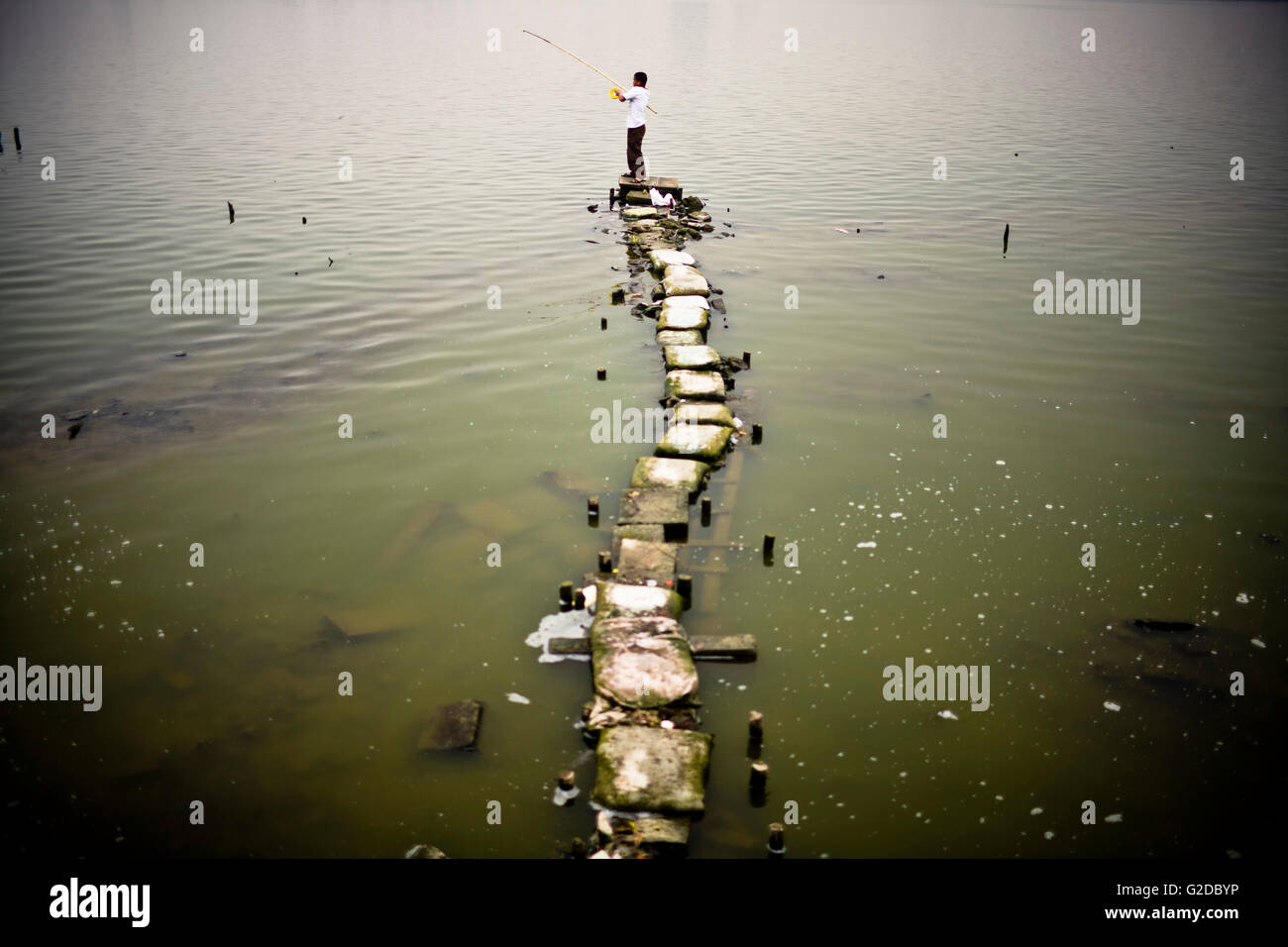 L'uomo la pesca dal molo di fortuna, Hanoi, Vietnam Asia Foto Stock