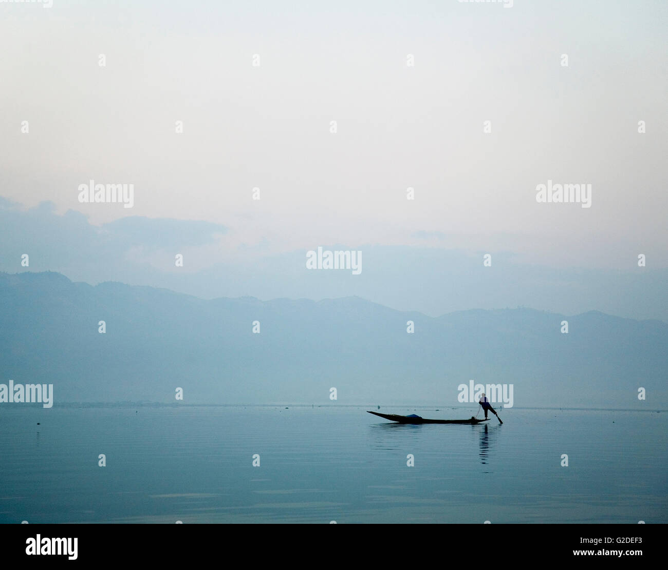 Silhouette di uomo gamba canottaggio sul lago, Myanmar Foto Stock