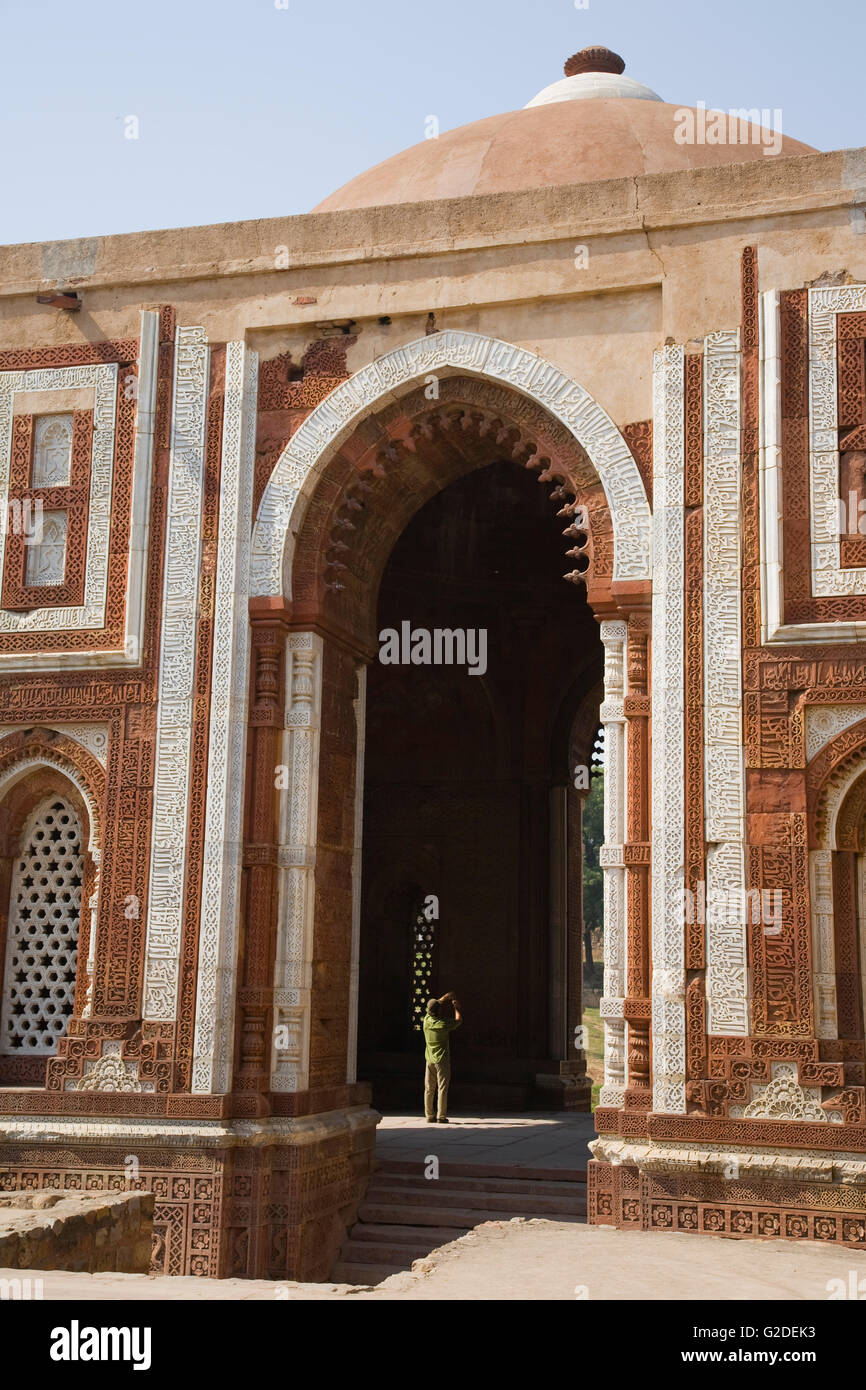 Uomo di scattare una foto in arco di Tall moschea, Qutb complessa, Delhi, India Foto Stock