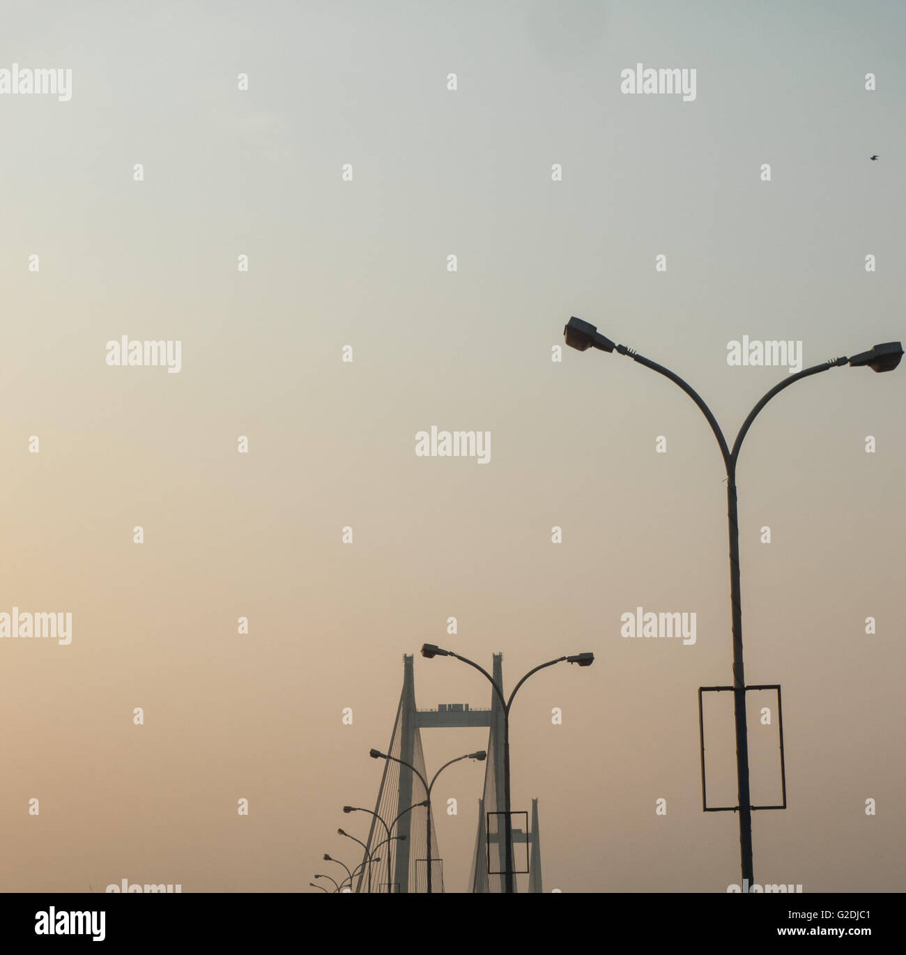 Vista in prospettiva laterale in colpo di Vidyasagar Setu ponte enfasi sulla linea di lampioni con vista della torre di sospensione Foto Stock