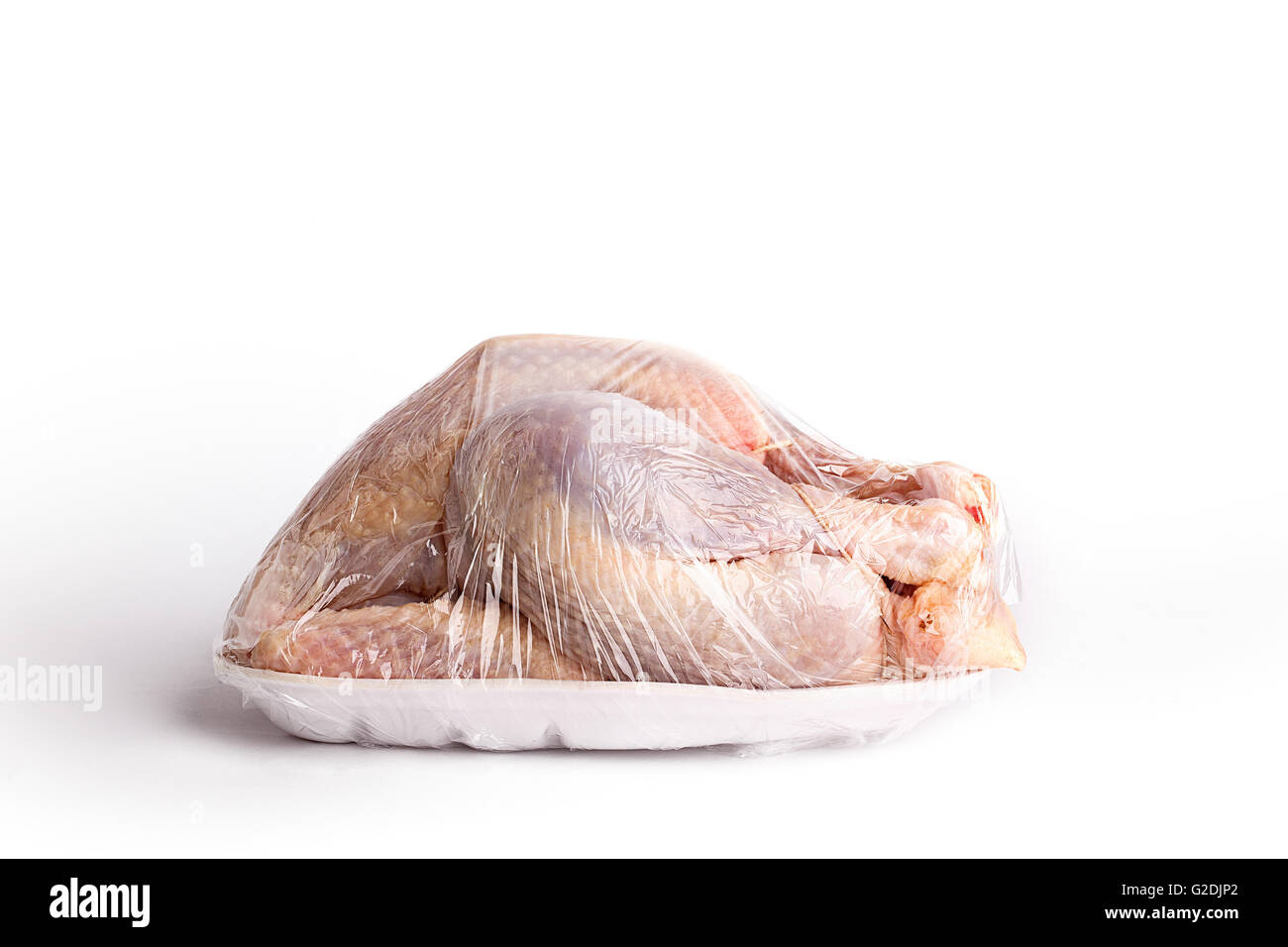 Crudo Intero pollo pizzicata su un dispositivo monouso styrofoam cestella in involucro di plastica Foto Stock