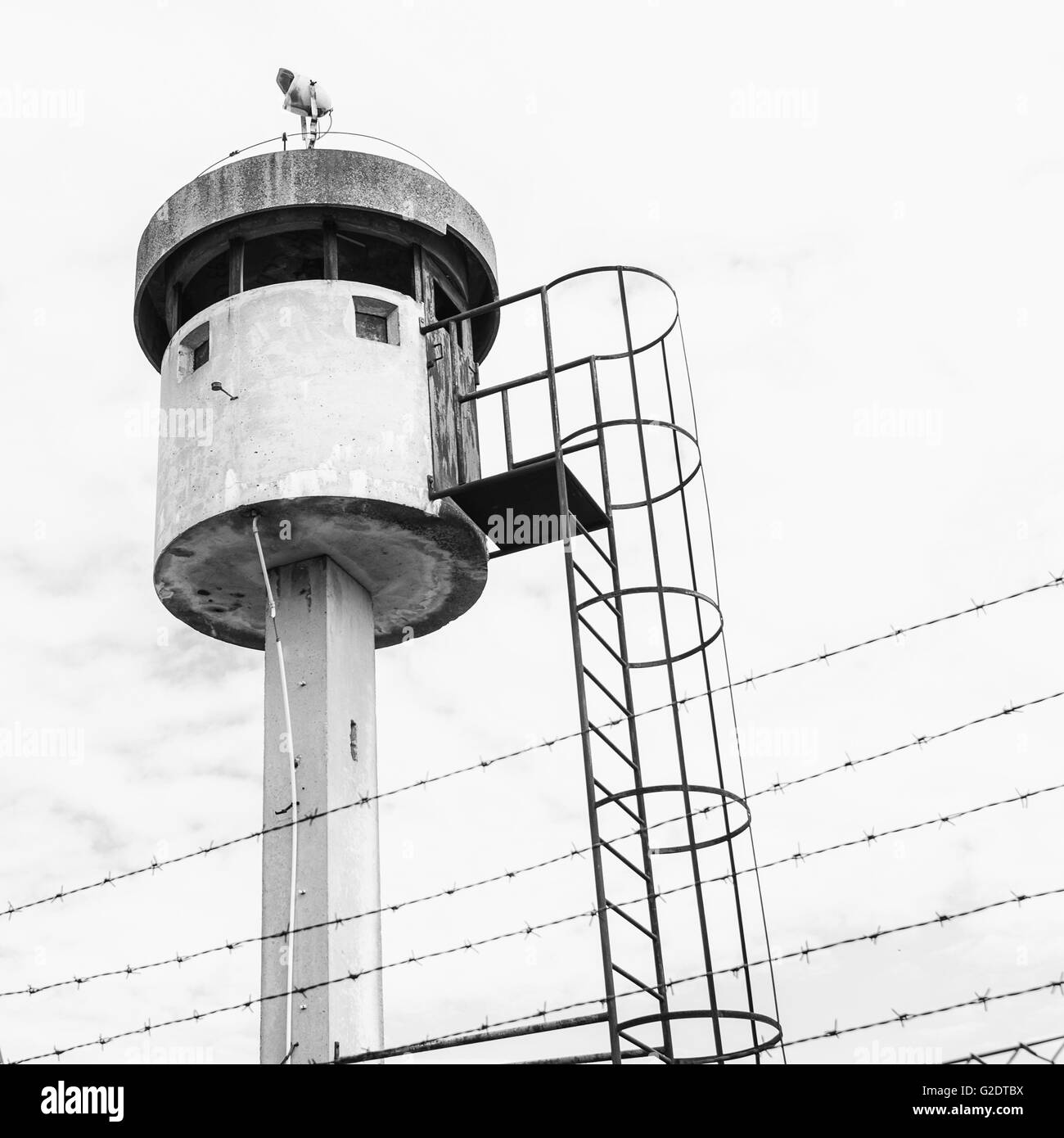 Abbandonato torre di avvistamento isolata da un netto e rabboccato con filo spinato. Foto Stock