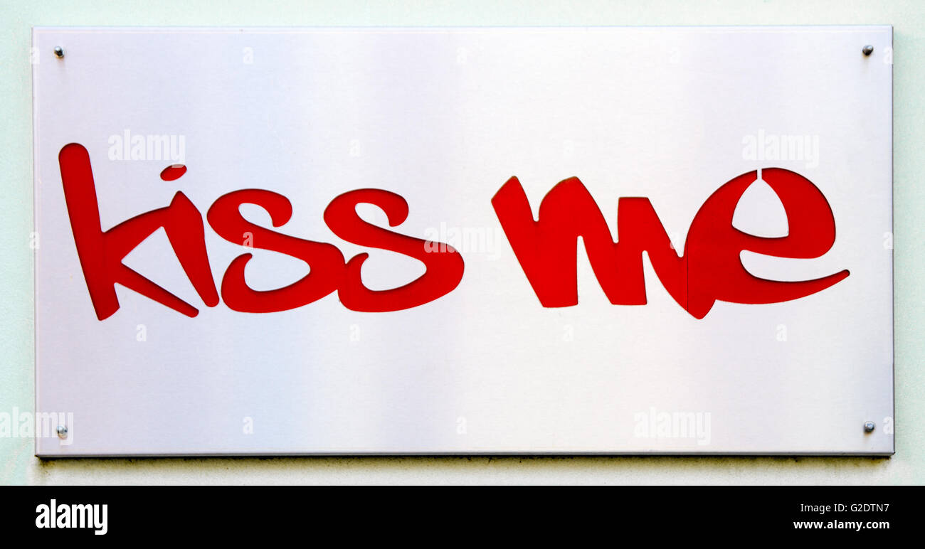 Placca in acciaio che dice 'kiss me' in rosso. Foto Stock