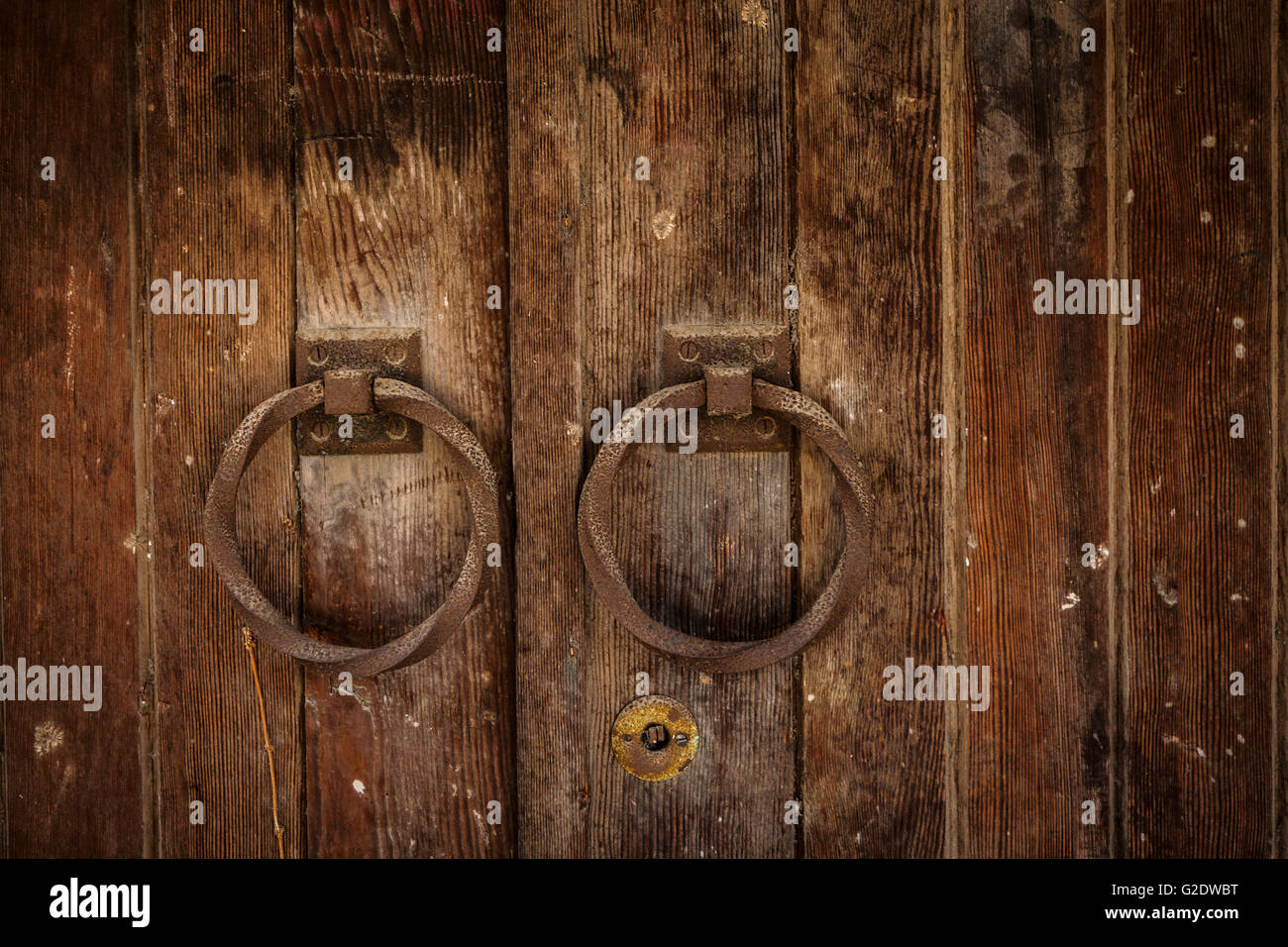 Vecchio arrugginito in legno facciata doppia porta con maniglie rotonde close-up Foto Stock