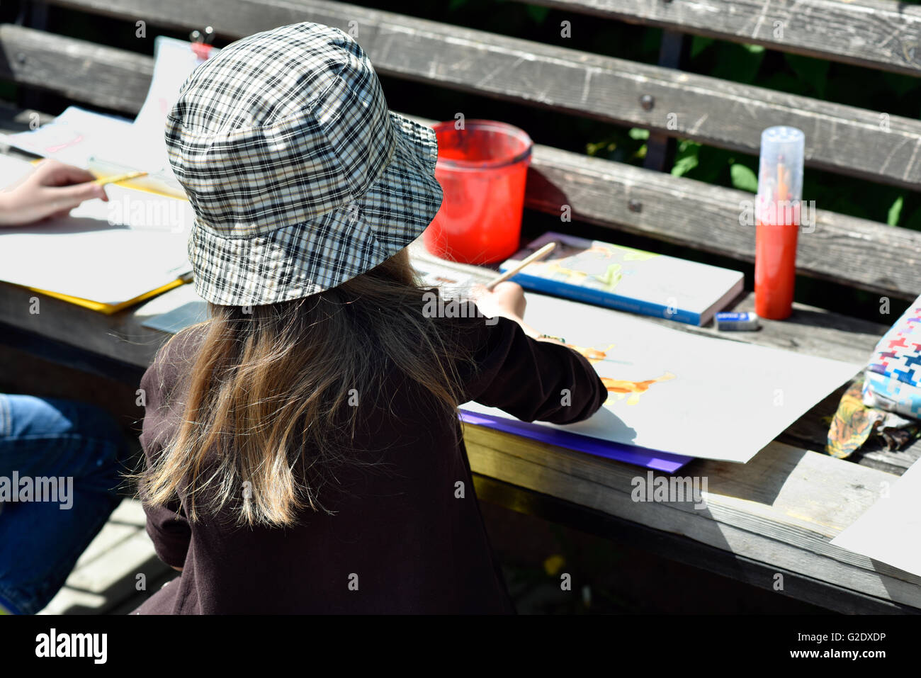 La bambina è impegnato nel disegno in un parco della città Foto Stock